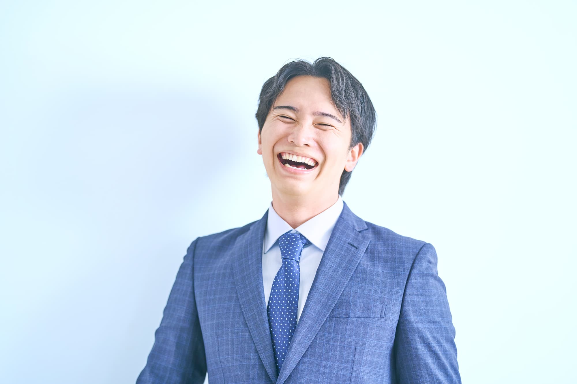 プラークの無い綺麗な歯を見せて笑う会社員